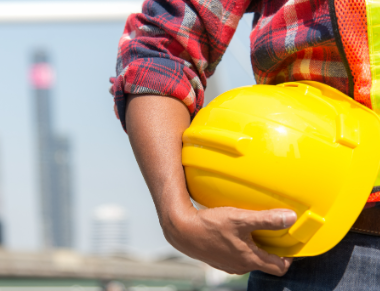 a man holding a yellow safety hat